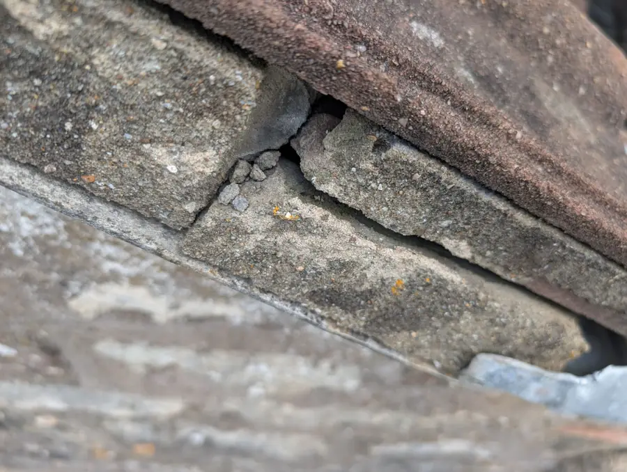 Cracked cement flashing at a chimney abutment, a common cause of roof leaks in Newcastle