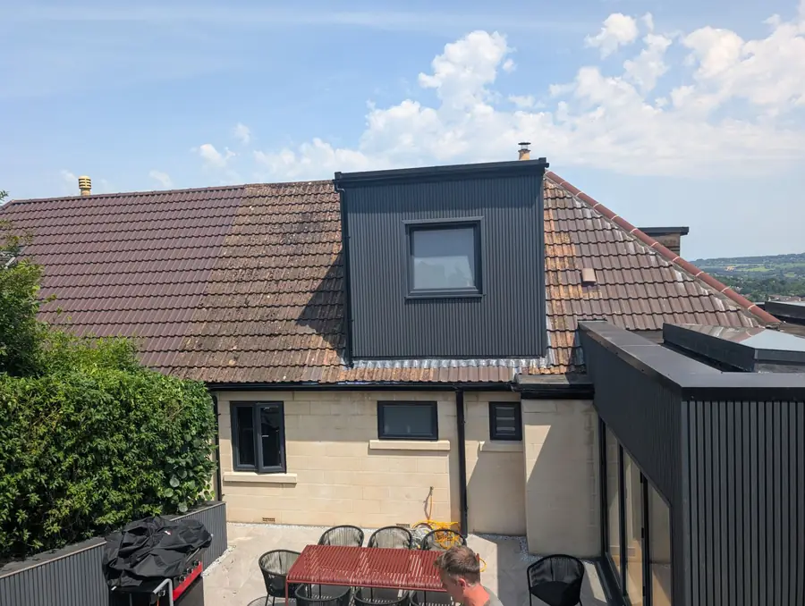 Rear of a house with a flat roof extension and a dormer window above