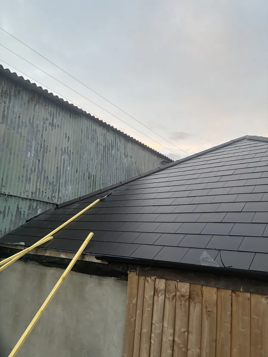Garage roof re-covered in slate beside a new timber fence